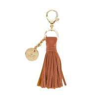 Brown tassel keychain with gold clasp and tag on a white background