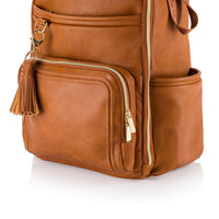 Brown leather backpack with gold zipper and tassel on a white background